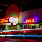 time lapse photography of car lights in front of cinema